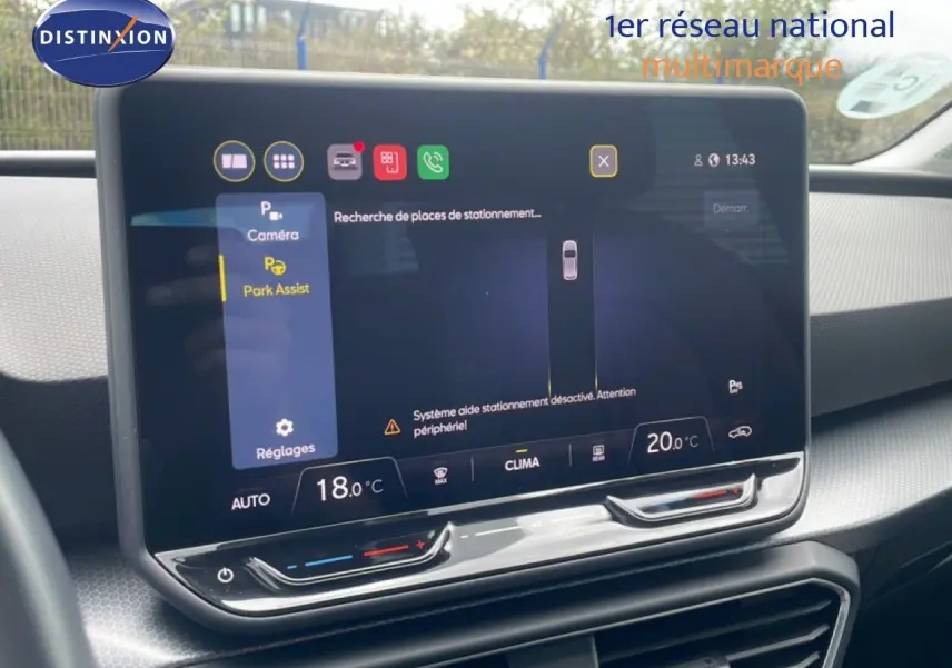 Écran tactile central affichant l'assistance au stationnement dans l'habitacle gris-noir d'une SEAT Leon blanche.