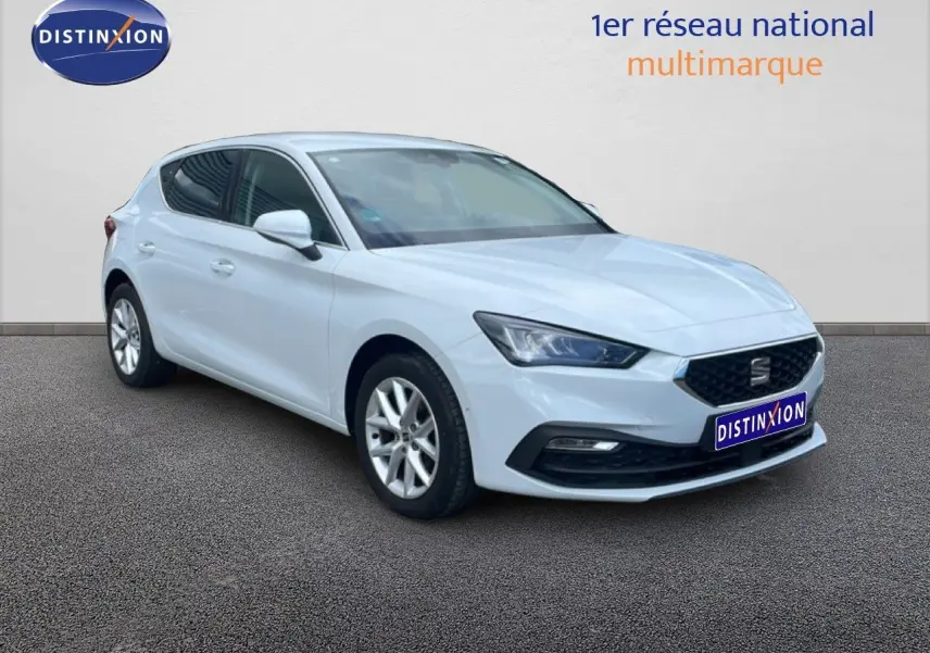 SEAT Leon 2025 blanc neige métal vue 3/4 avant droit avec calandre noire et jantes argentées.
