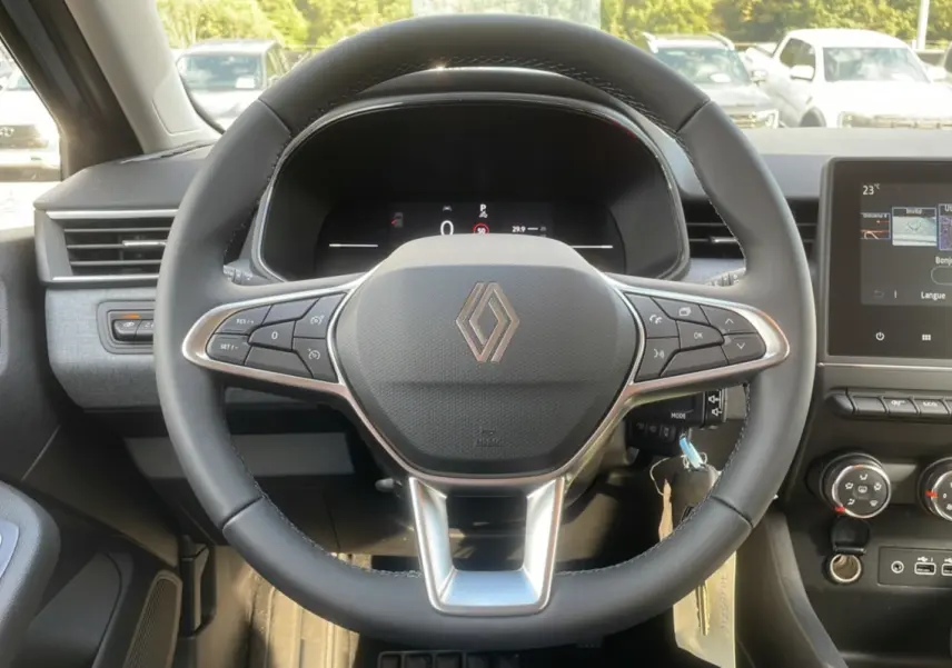 Vue intérieure centrée sur le volant multifonctions Renault Clio 2025, avec tableau de bord numérique et écran tactile.