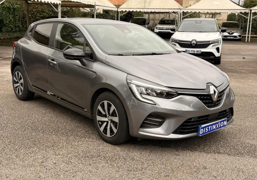 Renault Clio V gris schiste vue 3/4 avant droit, mettant en valeur ses phares LED et jantes bi-ton 16 pouces.