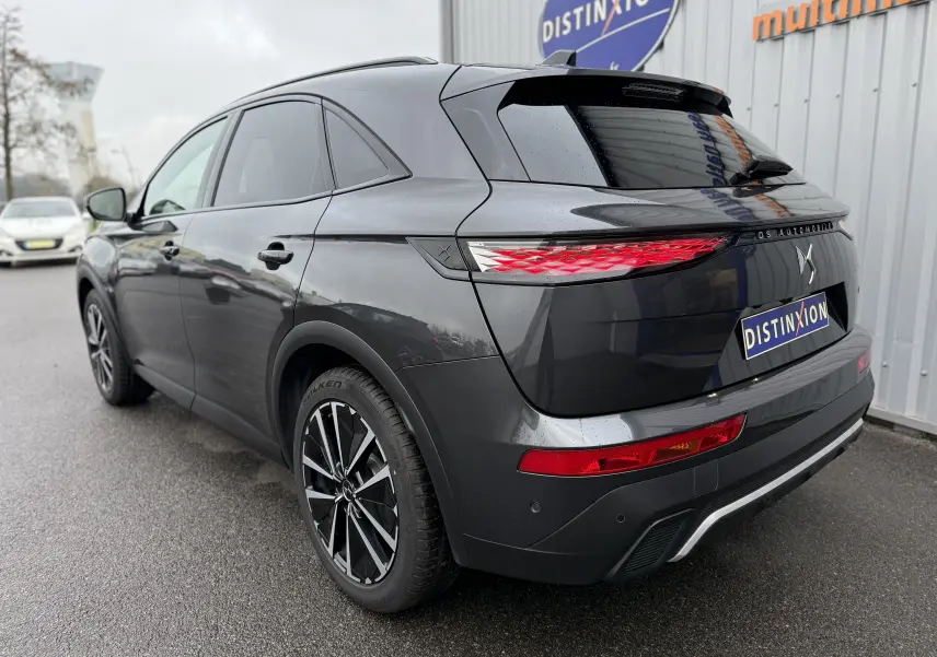 Vue 3/4 arrière droite du DS7 gris titane 2025 avec feux arrière LED et jantes alliage noires et argentées.