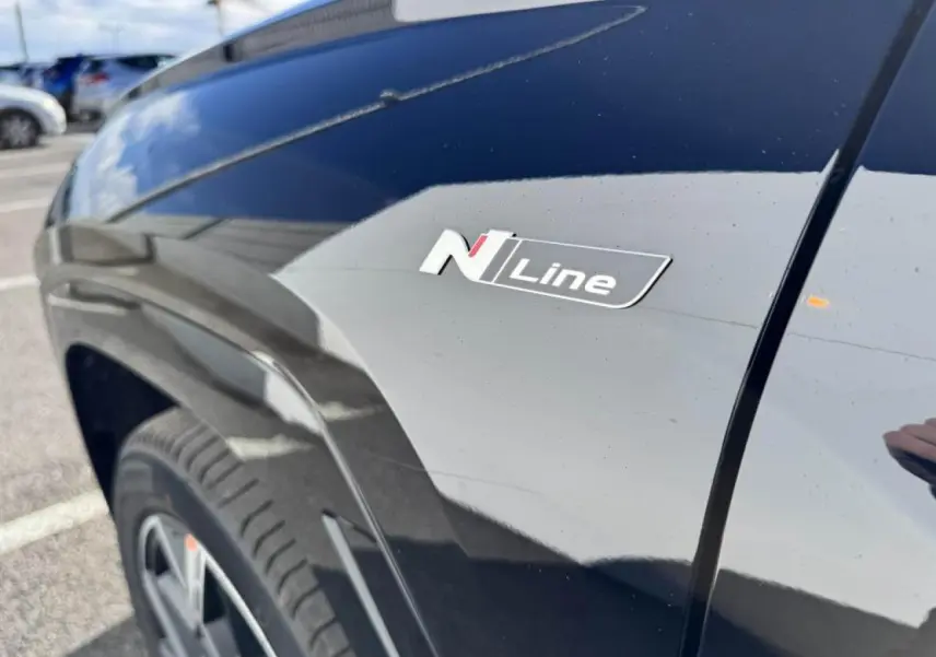 Gros plan sur l'aile avant gauche noire Abyss Metal du Hyundai Tucson 2025 avec badge N Line distinctif.