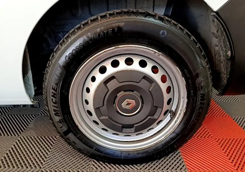 Gros plan sur la roue avant droite blanche d’un Renault Express 2021 avec jante acier et logo Renault central.