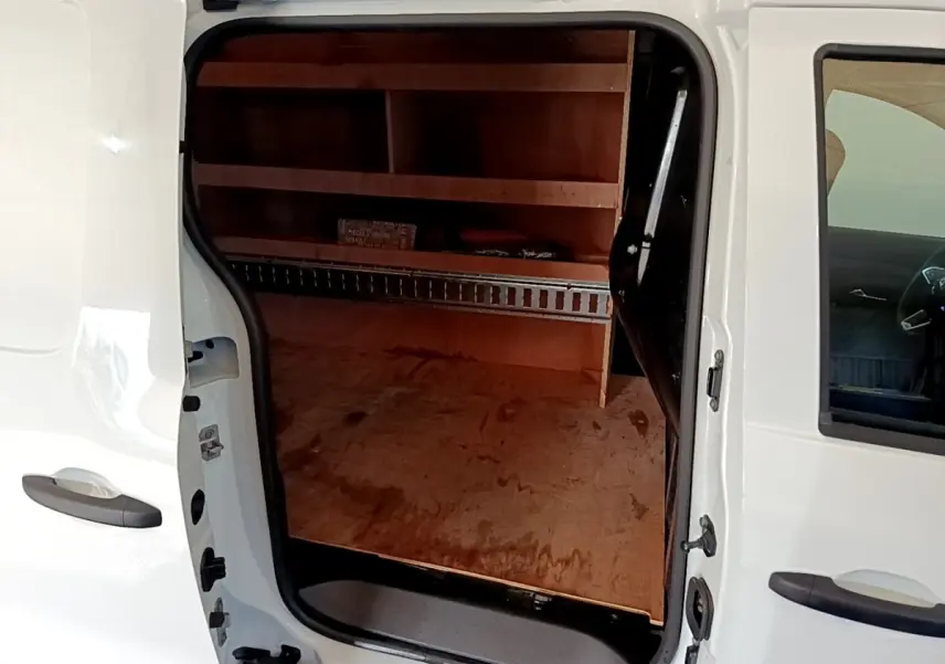 Vue latérale gauche d’un Renault Express blanc avec porte coulissante ouverte montrant l’espace de chargement en bois.