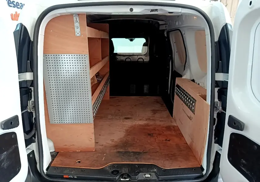 Vue arrière du Renault Express blanc 2021 avec aménagement bois et cloison pleine vitrée dans l’espace de chargement.