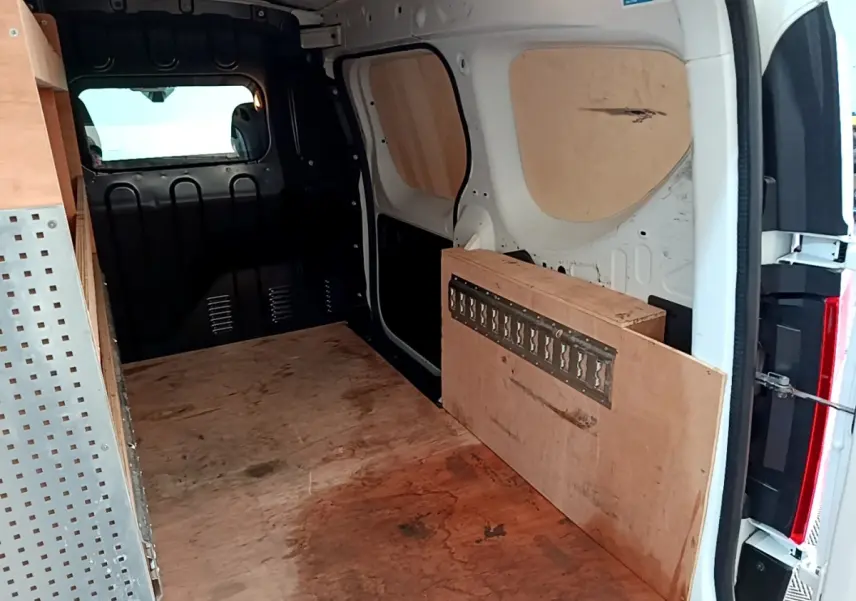 Vue intérieure arrière du Renault Express blanc 2021 avec cloison pleine et aménagements en bois.