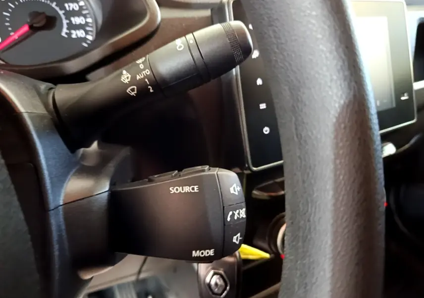 Gros plan sur la commande audio au volant noir du Renault Express 2021, avec tableau de bord et écran tactile visibles.