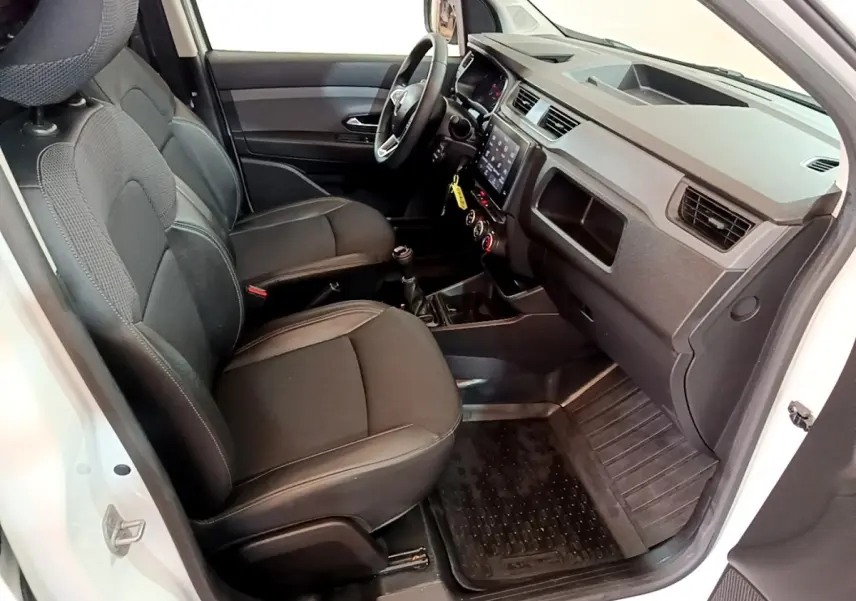 Vue intérieure côté conducteur du Renault Express blanc 2021, montrant sièges noirs et tableau de bord avec écran tactile.