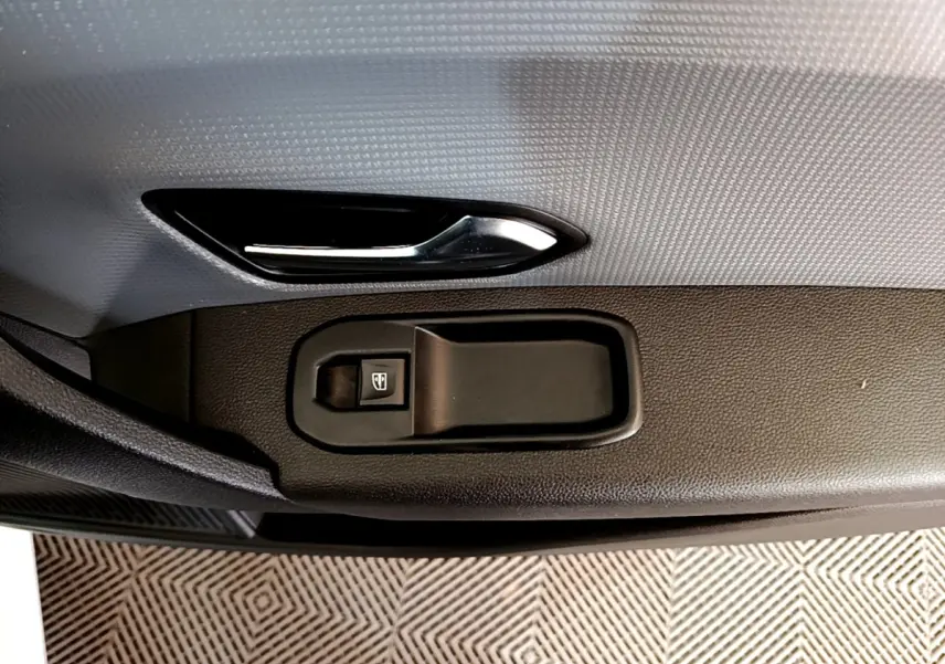 Gros plan sur la poignée intérieure et le bouton de lève-vitre côté conducteur du Renault Express Confort 2021.