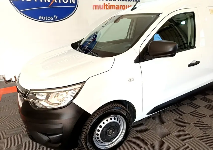 Vue 3/4 avant droit d'un Renault Express blanc avec pare-chocs noirs et jantes acier en intérieur showroom.