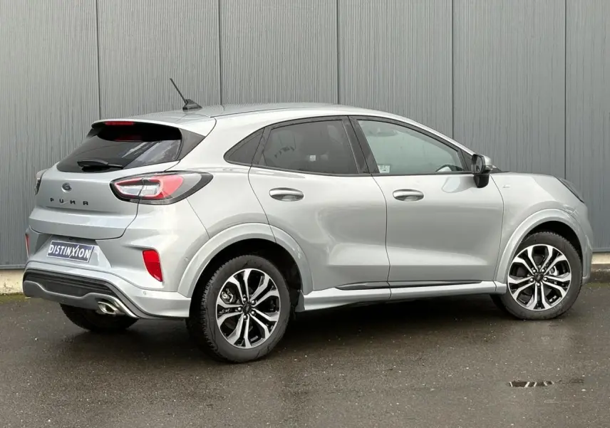 Ford Puma gris Solar vue 3/4 arrière droit, avec jantes alliage 17 pouces et hayon électrique visible.