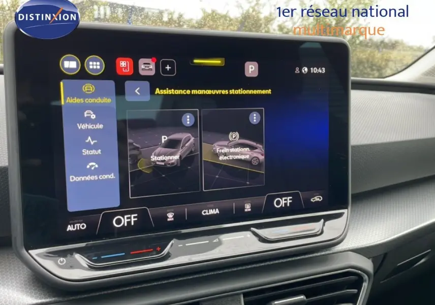 Vue intérieure du tableau de bord de la SEAT LEON bleu Fjord 2025, avec écran tactile affichant l'assistance au stationnement.