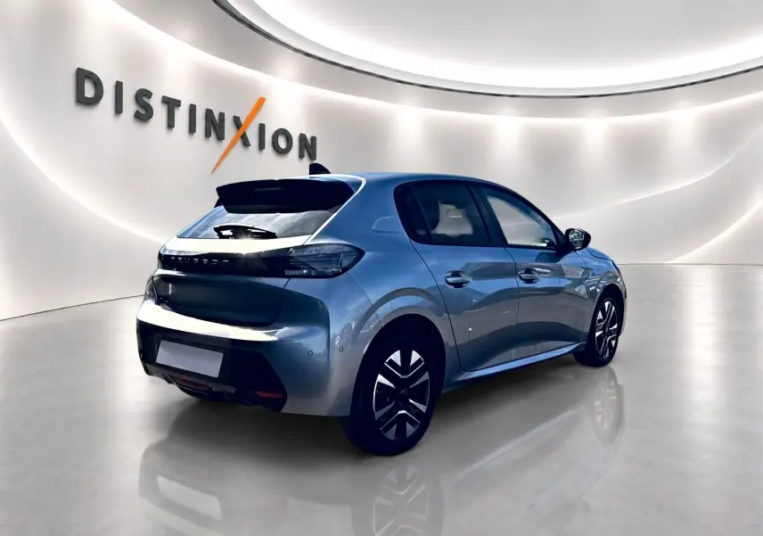 Peugeot 208 gris artense vue 3/4 arrière droit dans un showroom lumineux avec jantes alu distinctives.