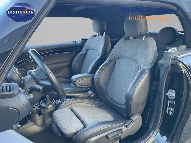 Intérieur avant de MINI Cabriolet Cooper 2023 en Midnight Black II, sièges tissu et similicuir gris, vue côté gauche porte ouverte.