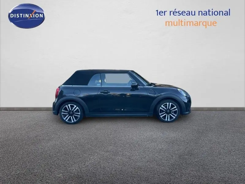 Vue de profil côté gauche d'une MINI Cabriolet 2023 Midnight Black II avec capote fermée et jantes alu distinctives.