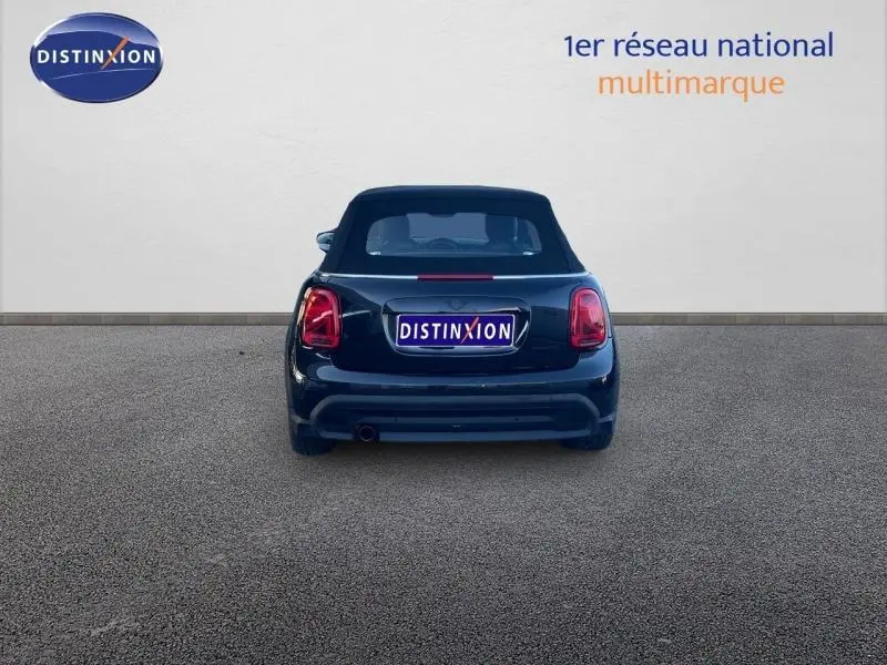 Vue arrière d'une MINI Cabriolet Cooper Midnight Black II avec capote fermée et feux arrière LED allumés.