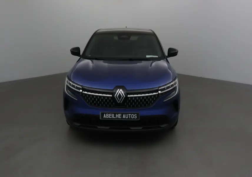 Vue frontale d'un Renault Austral bleu iron avec toit noir, mettant en valeur sa calandre moderne et ses phares LED fins.