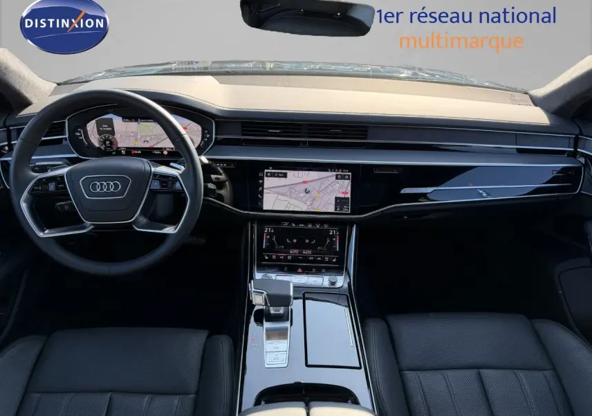 Vue intérieure avant de l'Audi A8 2024 noire Sebring Cristal, tableau de bord moderne avec écran tactile et volant multifonction.
