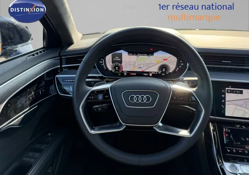 Vue intérieure centrée sur le volant noir et le tableau de bord numérique de l'Audi A8 AVUS 2024.