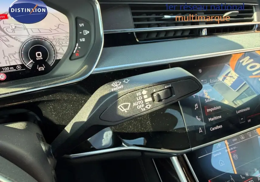 Gros plan sur la commande d’essuie-glace dans l’habitacle d’une Audi A8 noire Sebring Cristal 2024, tableau de bord digital visible.