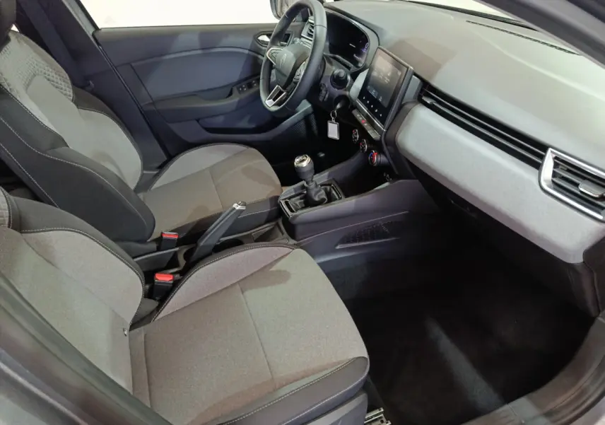 Intérieur avant de la Renault Clio Evolution Blue dCi 100 2025, vue côté conducteur, sièges gris et tableau de bord moderne.