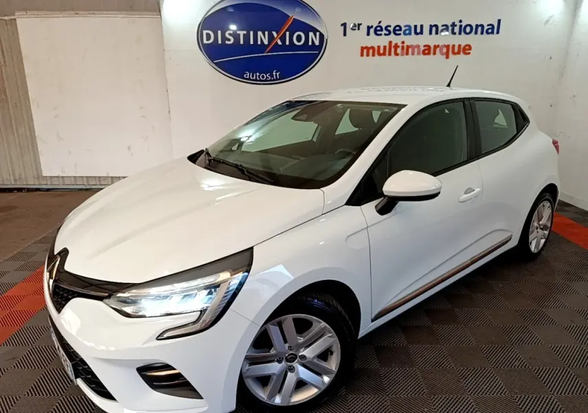 Renault Clio Business Blue dCi 115 blanche vue en 3/4 avant droit avec phares LED allumés en intérieur showroom.