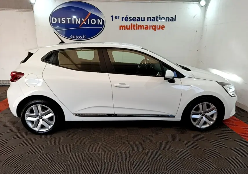 Profil côté gauche d'une Renault Clio Business Blue dCi 115 blanche, vue en intérieur avec jantes alliage et vitres teintées.