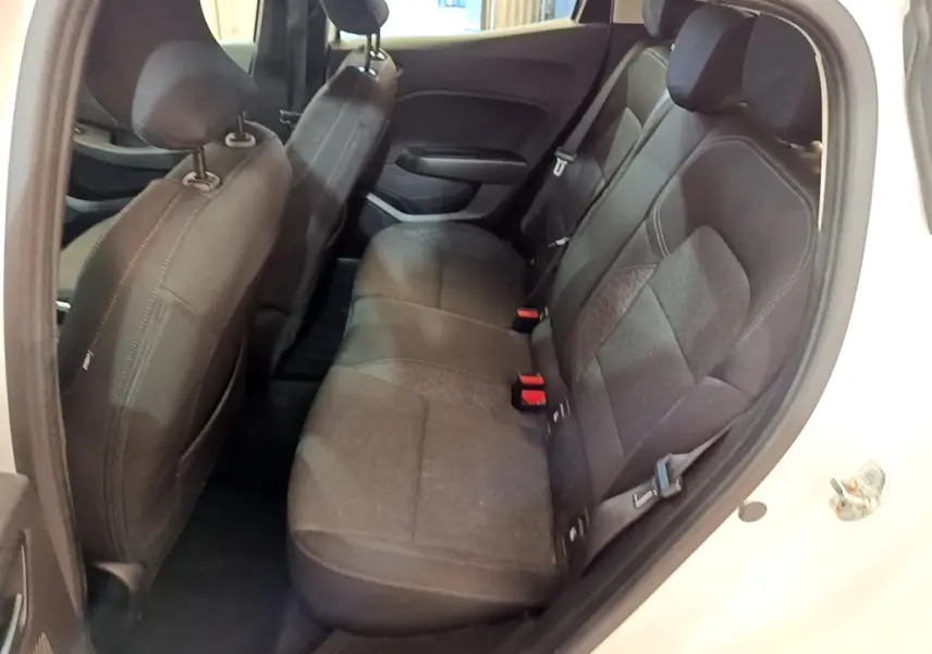 Vue intérieure côté droit montrant la banquette arrière noire et les sièges avant d'une Renault Clio blanche 2020.