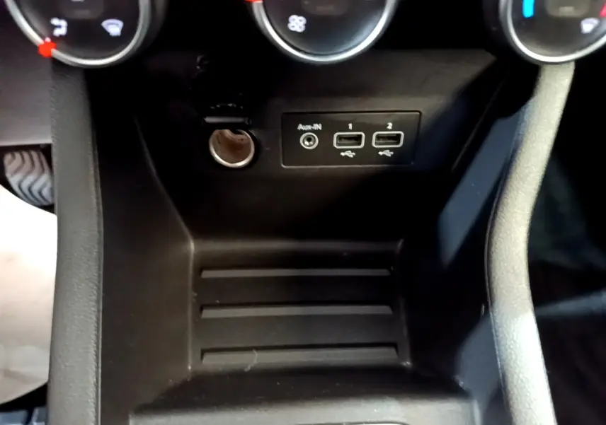 Gros plan sur la console centrale noire de la Renault Clio Business Blue dCi 115, avec prises USB et prise auxiliaire.