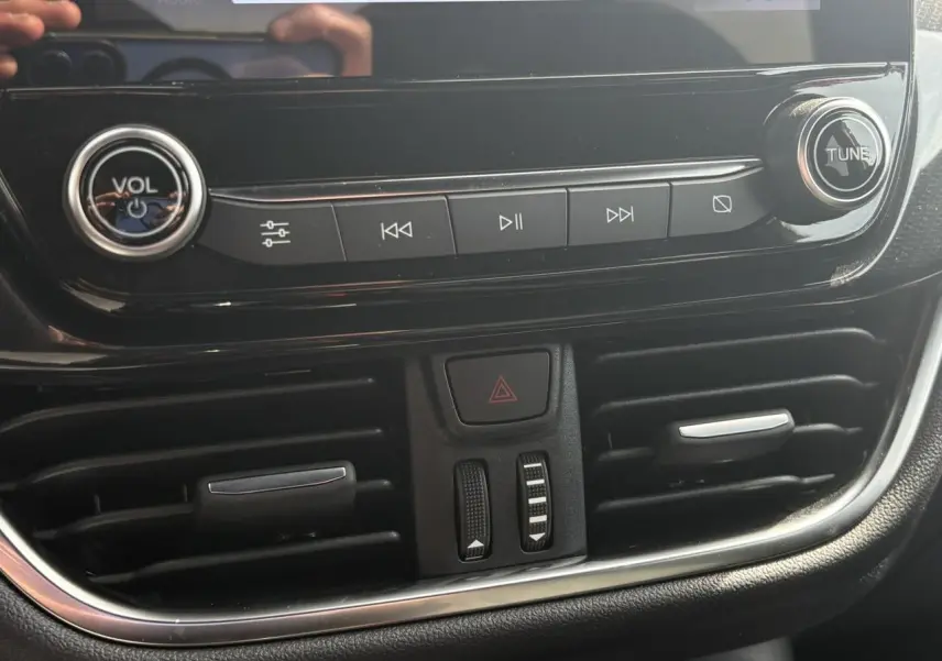 Gros plan sur la console centrale noire du Ford Puma 2023, avec commandes audio et aérateurs visibles.