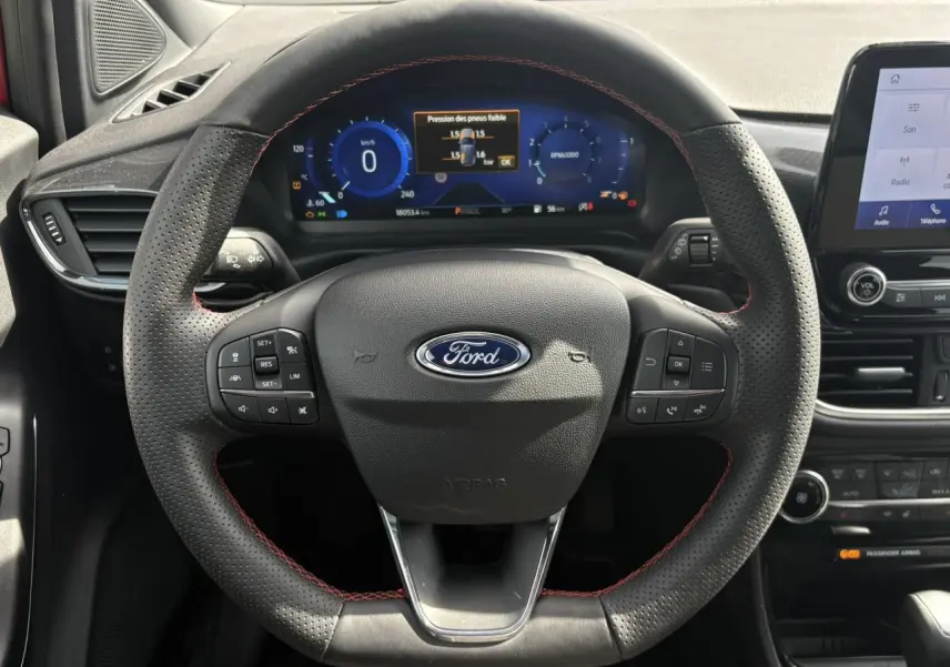 Vue centrée sur le volant perforé ST-Line avec surpiqûres rouges et tableau de bord numérique de la Ford Puma 2023.