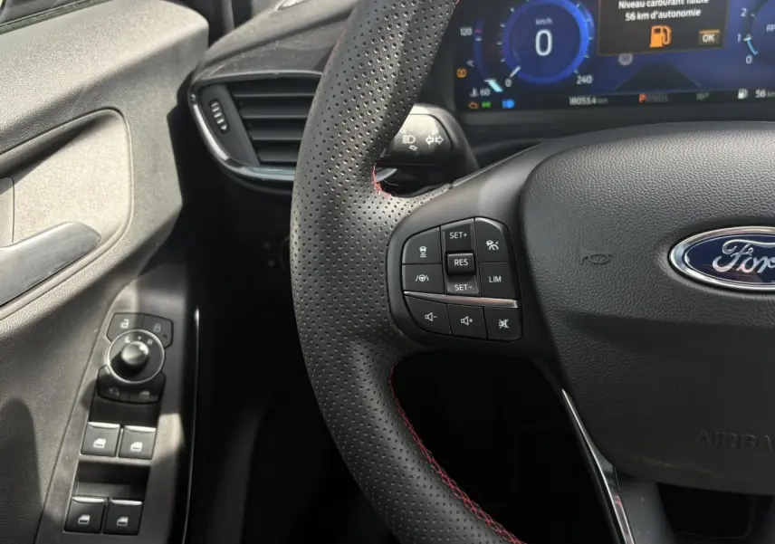 Vue rapprochée du volant perforé ST-Line avec commandes intégrées et tableau de bord numérique du Ford Puma 2023.