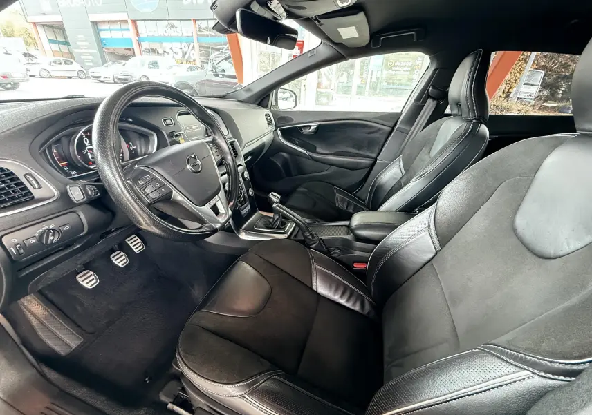 Intérieur noir cuir de la Volvo V40 R-Design 2017, vue côté conducteur avec volant multifonction et boîte manuelle.