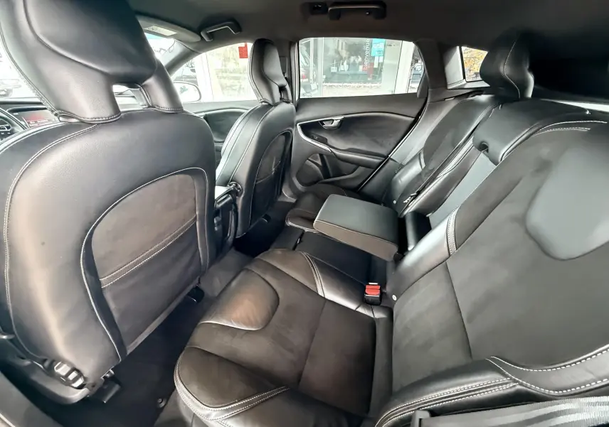 Intérieur arrière de la Volvo V40 R-Design 2017, sièges noirs en cuir avec accoudoir central déployé, vue côté droit.
