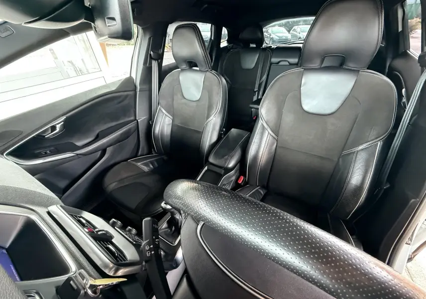 Intérieur noir de la Volvo V40 R-Design 2017, vue avant des sièges en cuir et alcantara avec volant perforé.