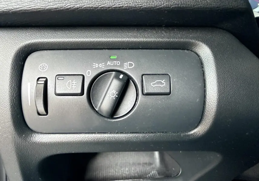 Gros plan sur le panneau de commande des phares et du coffre d'une Volvo V40 R-Design blanche de 2017.