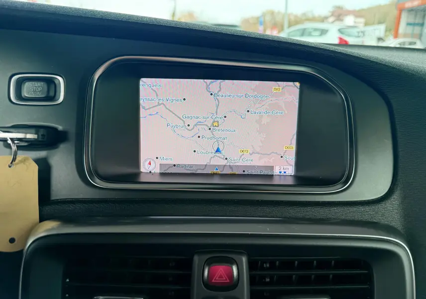 Écran de navigation intégré au tableau de bord noir d'une Volvo V40 R-Design blanche, vue intérieure frontale.