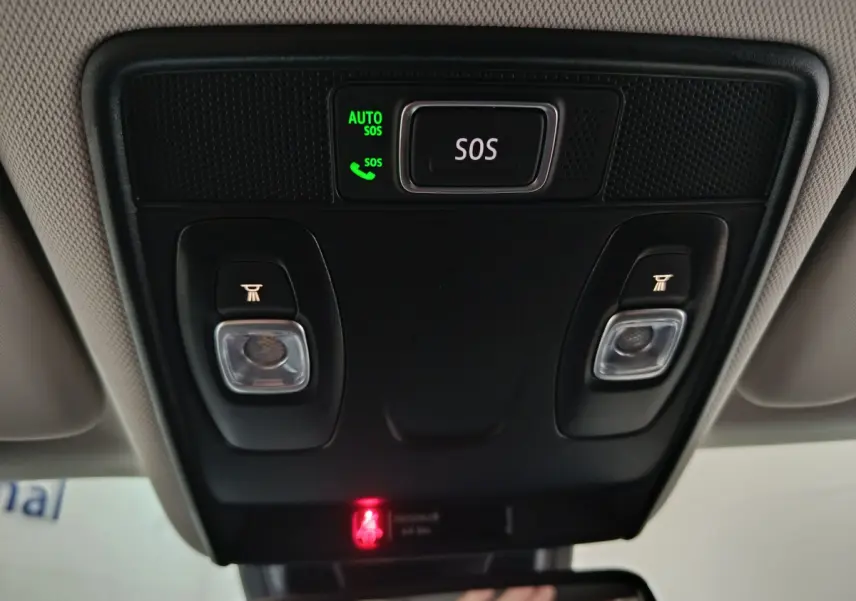 Gros plan sur la console de toit intérieure du Renault Captur rouge 2024 avec bouton SOS et éclairages intégrés.