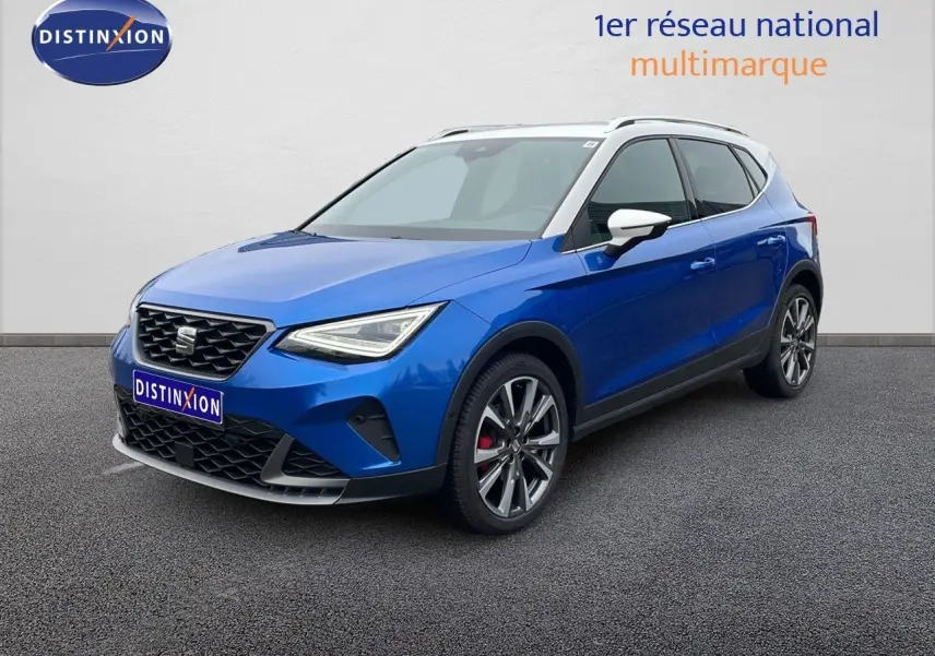 Vue 3/4 avant droite d’un SEAT Arona bleu saphir métal avec toit blanc et jantes alliage sport.