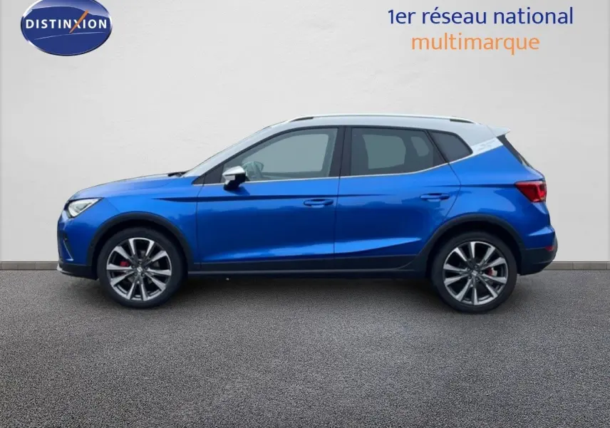 Vue latérale droite d'une SEAT Arona 2025 bleu saphir métal avec toit blanc et jantes alliage sport.