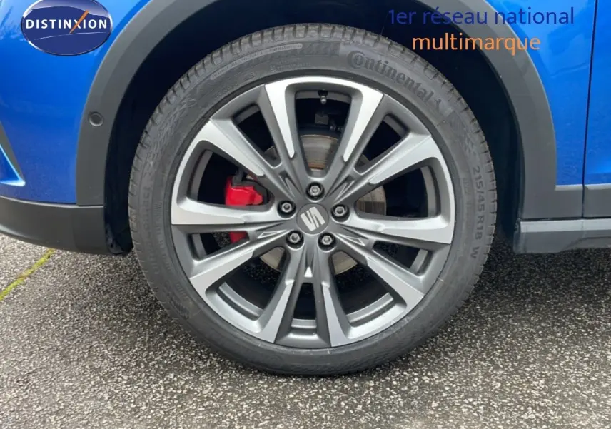 Gros plan sur la roue avant droite du SEAT Arona bleu saphir métal avec étrier de frein rouge et jante alliage.