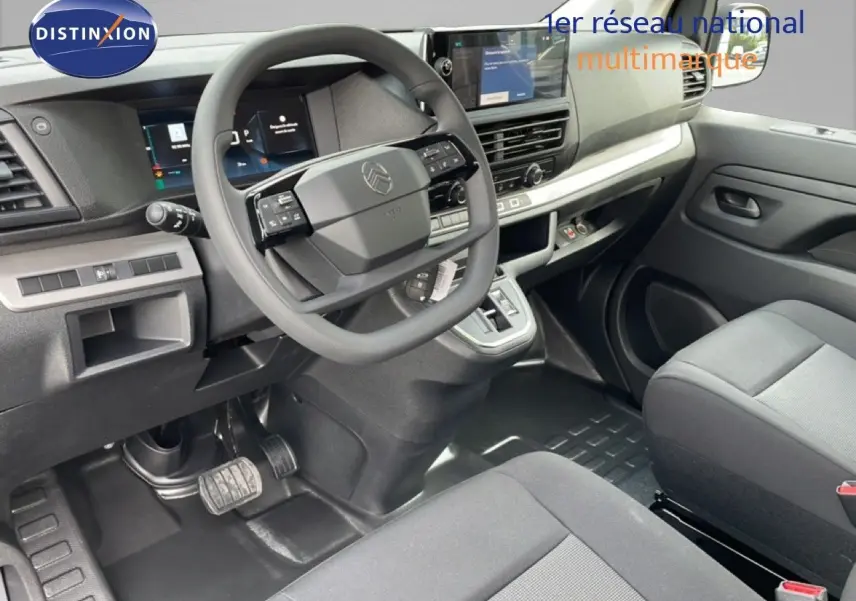 Vue intérieure côté conducteur du Citroën Jumpy cabine approfondie 2026, tableau de bord moderne avec volant multifonction gris.