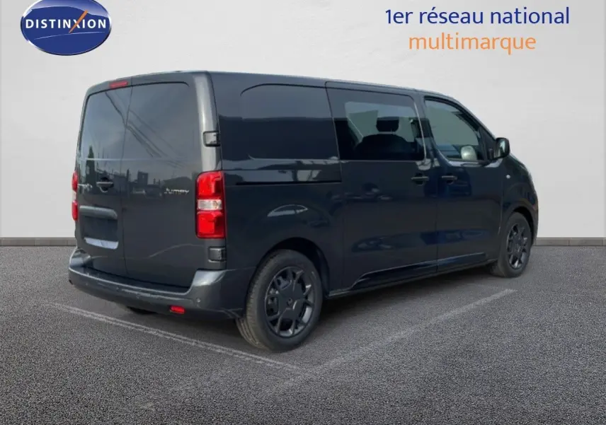 Vue 3/4 arrière droite d’un Citroën Jumpy cabine approfondie gris titane métallisé avec vitres teintées et feux arrière rouges.