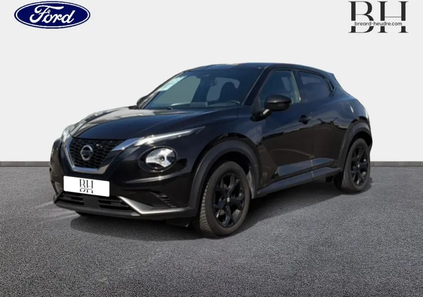 Nissan Juke noir métallisé vu en 3/4 avant droit, avec jantes noires et signature lumineuse distinctive.
