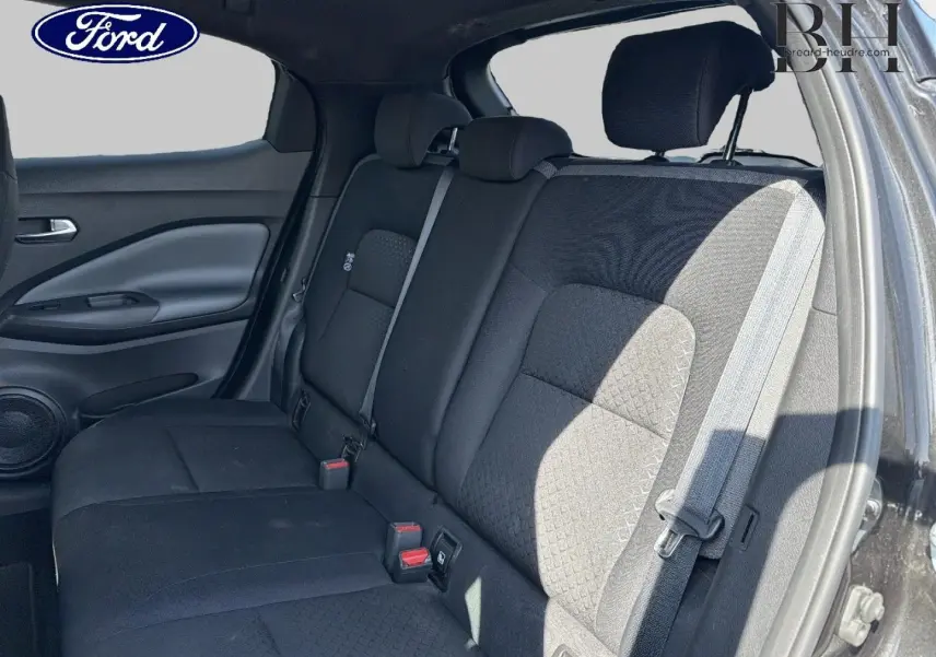 Vue intérieure sur la banquette arrière noire du Nissan Juke 2020, avec ceintures de sécurité et appuie-têtes visibles.