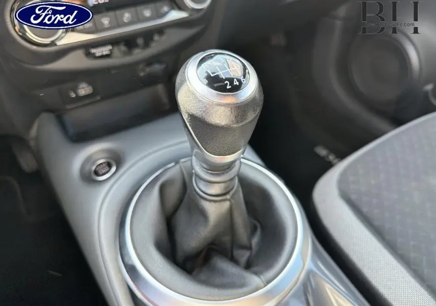Le levier de vitesses manuel en gros plan dans l'habitacle d'une Nissan Juke noir métallisé, vue côté passager.