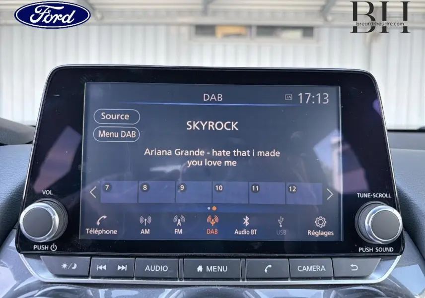 Écran tactile multimédia d'une Nissan Juke noir métallisé, affichant la radio DAB avec la station Skyrock en intérieur.