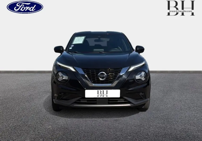 Vue frontale d'un Nissan Juke noir métallisé avec calandre en V chromée et phares ronds distinctifs.
