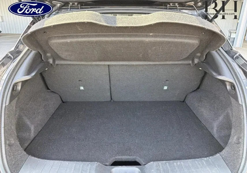 Coffre ouvert d'une Nissan Juke noir métallisé, vue de l'arrière montrant l'espace de chargement vide.