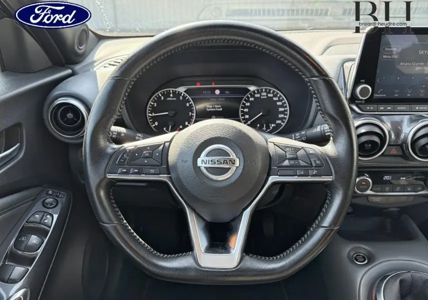 Vue intérieure centrée sur le volant cuir noir du Nissan Juke 2020 avec tableau de bord et écran tactile visibles.